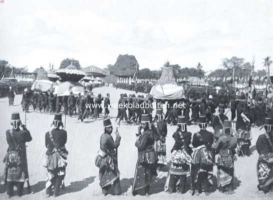 Indonesi, 1911, Surakarta, Solo. Het oogenblik waarop de stoet met de rijkversierde draagtafels met lekkernijen voor het volk den Kraton verlaten heeft en zijn weg kiest door de straten van Solo