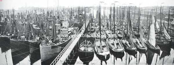 Noord-Holland, 1913, Ijmuiden, Gezicht van den watertoren te Ijmuiden tijdens de staking der visschers op de geheel met schepen gevulde visschershaven. Links van de loopplank de trawlers, rechts de botters