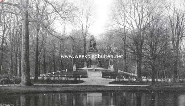 De halve eeuw van het Vondelpark. Vondel's gedenkbeeld in 1914, de boomen rondom zijn opgeschoten en het voetstuk van het beeld is aan vervuiling prijsgegeven