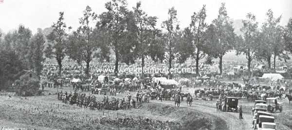 De strijd bij onze grenzen. De legerplaats der Duitschers aan de Maas bij Mouland. Links op het veld vooraan de 60-tal Belgische soldaten, krijgsgevangen en omringd door Duitschers