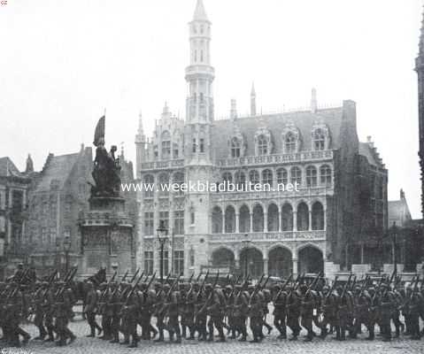 De intocht van de Duitschers in Brugge. Soldaten, over de Groote markt marchereerende langs het gedenkteeken, opgericht ter eere van Jan Breydel en Pieter de Coninck