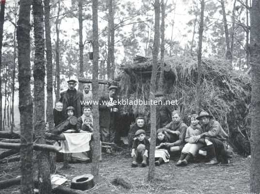 Noord-Brabant, 1914, Bergen op Zoom, Belgische vluchtelingen na den val van Antwerpen in de bosschen bij Bergen-op-Zoom voor een hut, door padvinders opgericht, die hun voedsel geven