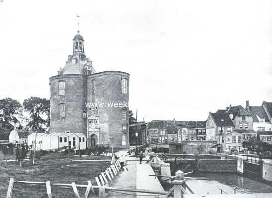 Noord-Holland, 1915, Enkhuizen, De gerestaureerde Drommedaris te Enkhuizen. De Drommedaris vr de restauratie, met de ontsierende barakken, die thans verdwenen zijn