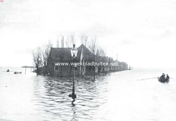 De watersnood in Noord-Holland. Huizen aan den weg van Zaandam naar Oostzaan, thans een eilandje in een groot meer vormend