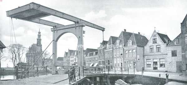 Noord-Holland, 1916, Hoorn, Hoorn, de zeshonderdjarige. Hoofdtoren en Veermanskade. In het huisje rechts op de afbeelding, in welks zeer ontsierende gevel een steen prijkt, voorstellende een bonte koe, hield de vader van Willem Ijsbrantszoon Bontekoe, de bekende zeevaarder en schrijver van 