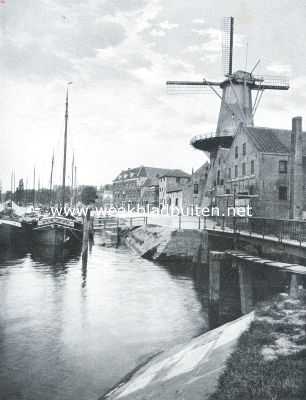 De gebouwen der Oost-Indische Compagnie. Gezicht op de Achterhaven te Delfshaven, het hooge breede huis op het midden der afbeelding is het voormalige Zeemagazijn van de kamer Delft der Oost-Indische Compagnie