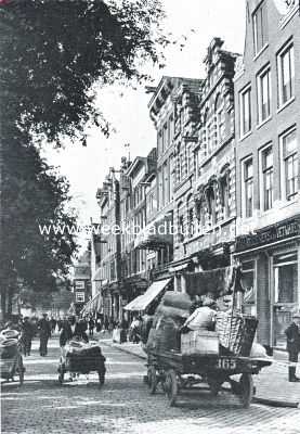 Bij de Nieuwmarkt te Amsterdam. De dadelijk op deze afbeelding opvallende huizen met trapgevels van 't jaar 1605, voorbeelden van een in de hoofdstad betrekkelijk zeldzaam type, zijn door de vereeniging 