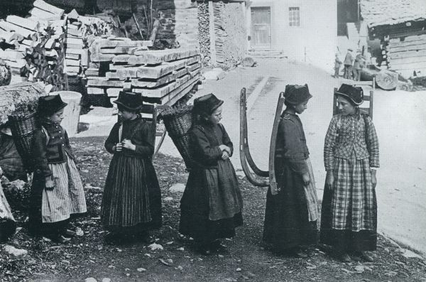 Zwitserland, 1932, Onbekend, Gletschersagen uit het Loetschendal. Meisjes uit het Loetschendal in kjleederdracht. De houten toestellen dienen om de lasten te vervoeren