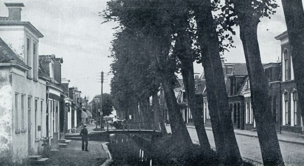 Friesland, 1933, Sint Annaparochie, EEN TYPISCH DORPSSTRAATJE TE SINT ANNA-PAROCHIE, met Sint Jacobi-Parochie en Vrouwbuurt het drietal Bildt-dorpen vormende. Deze straat heeft reeds een steedsche, zij het een kleinsteedsche allure