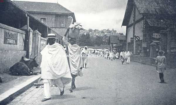 Madagascar, 1936, Antananarivo, Een inwoner van Tananarive keert huiswaarts van de markt met zijn bediende, die de inkoopen - bovenop een witte gans -  in een mand op het hoofd draagt